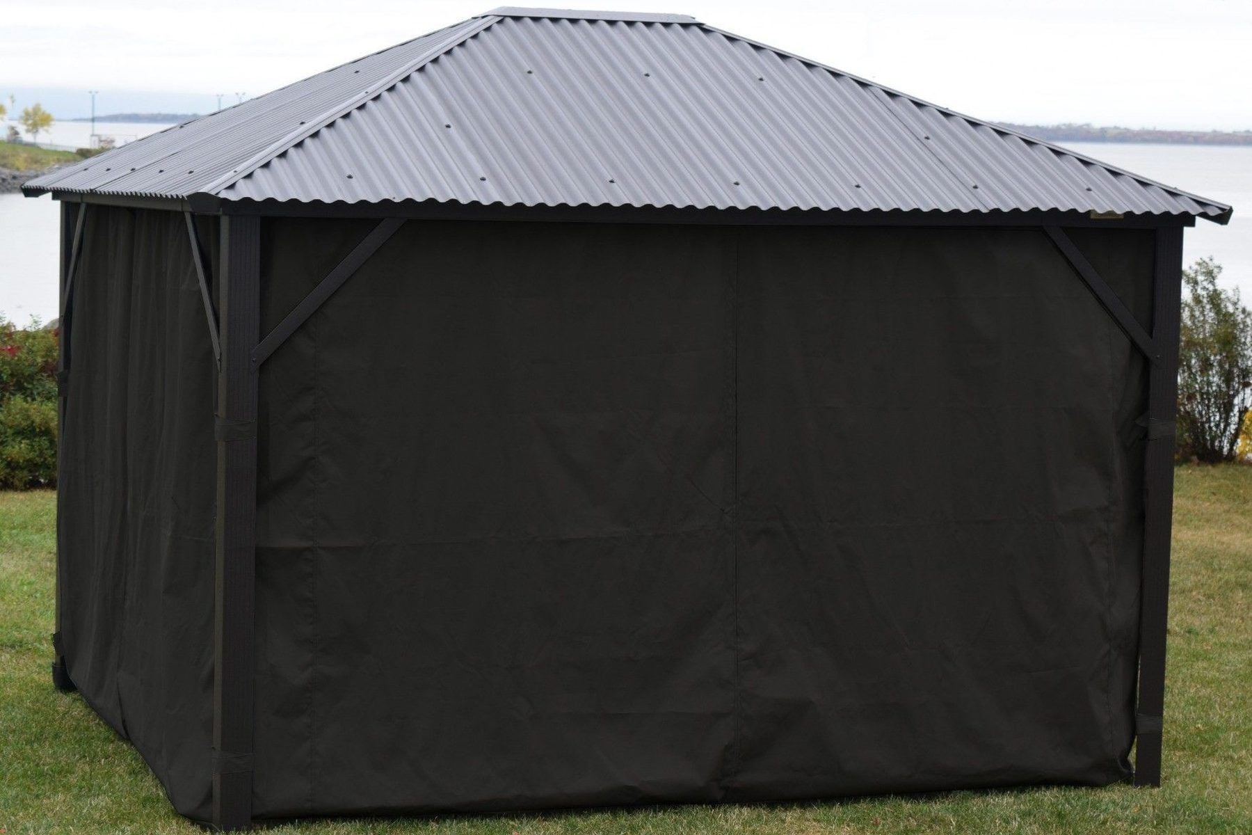 Gazebo à toit rigide entièrement fermé avec des rideaux latéraux Safezone noirs de Corriveau au bord de l'eau en automne