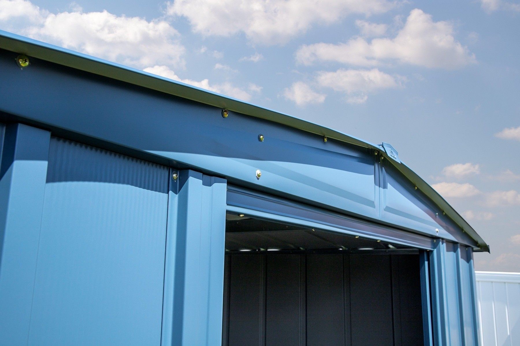 Portes coulissantes ouvertes sur un cabanon en acier Arrow Classic bleu-gris, montrant le rail et l'ouverture