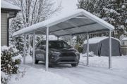 Abri d'auto en acier enneigé protégeant un véhicule pendant un hiver canadien