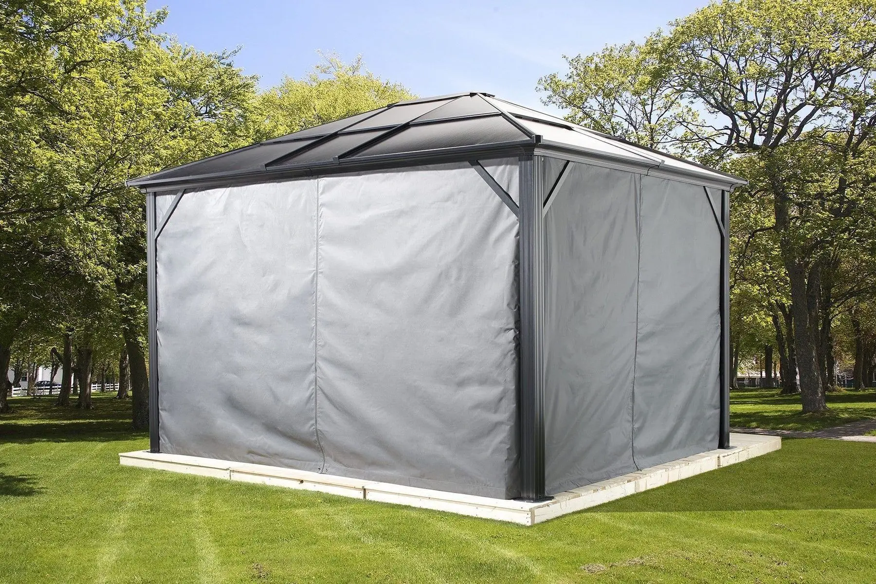 Gazebo fermé avec des rideaux latéraux gris dans une cour canadienne